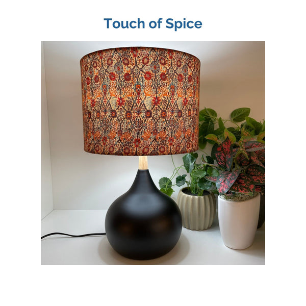 Touch of Spice fabric on medium drum lampshade and black touch base, lit, crafted by shades at grays