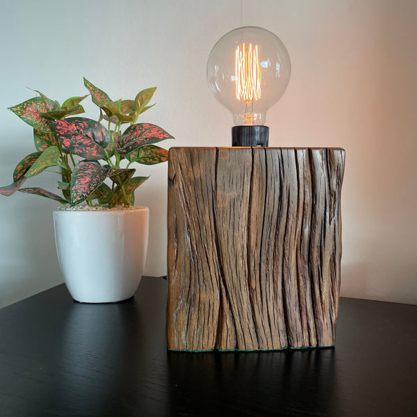 Unique timber wood lamp created from reclaimed wharf timber, lit,  front view.