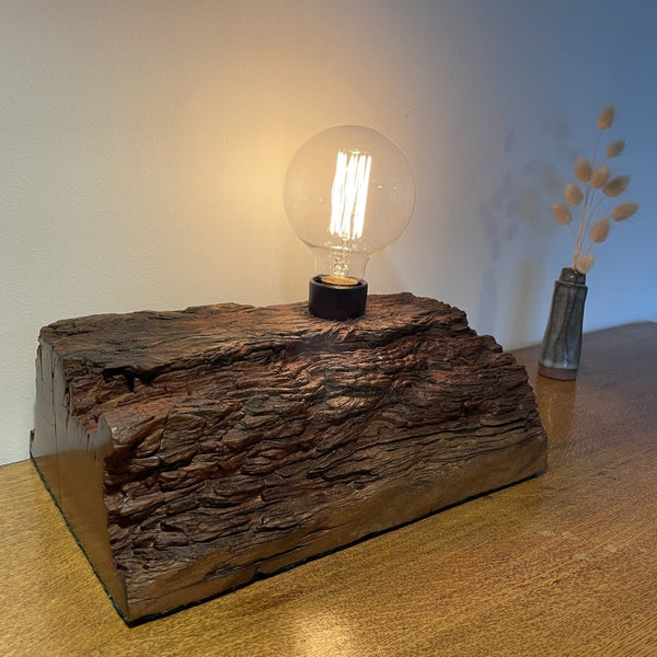 Rustic wood table lamp handcrafted from upcycled jarrah wharf timber, front view of wave patterned erosion grooves and replica edison bulb, by shades at grays.