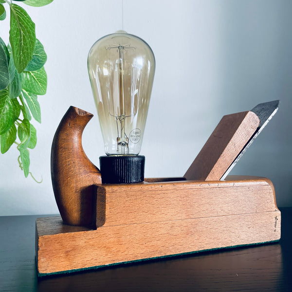 Original vintage wood plane lamp with edision bulb, unlit, by shades at grays.