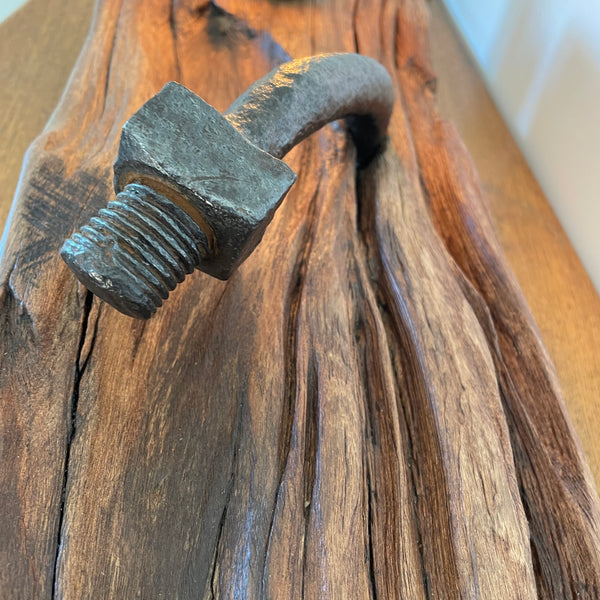 Close up of original bolt contrasting with erosion grooves of polished wood.