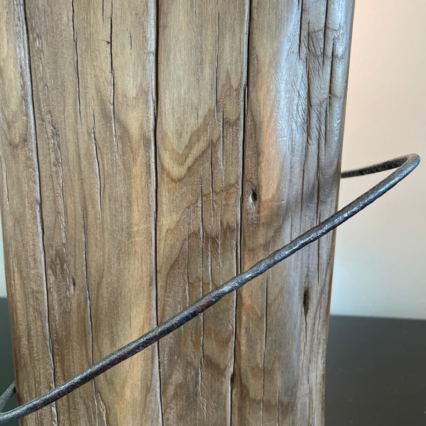 Rustic tōtara fence post crafted into a wood table lamp with replica edison bulb by shades at grays, close up of original NO8 wire and wood grain.