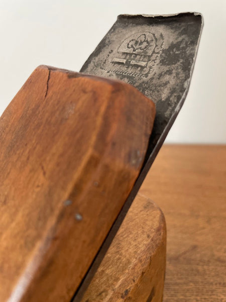 Upcycled carpenter's plane into wood table lamp by shades at grays close up of original brand.