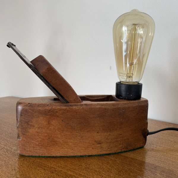 Upcycled carpenter's plane into wood table lamp by shades at grays with replica edison bulb, unlit, long view.