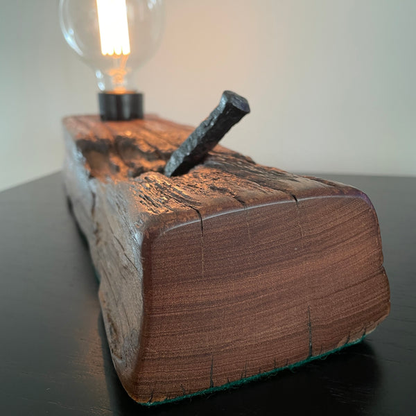 Upcycled wood table lamp from origianl wharf timber, vintage nail and replica edison bulb, lit, side view and close up of nail, sold by shades at grays.