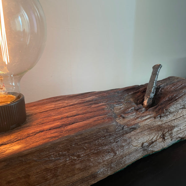 Upcycled wood table lamp from origianl wharf timber, vintage nail and replica edison bulb, lit, close up
, sold by shades at grays.