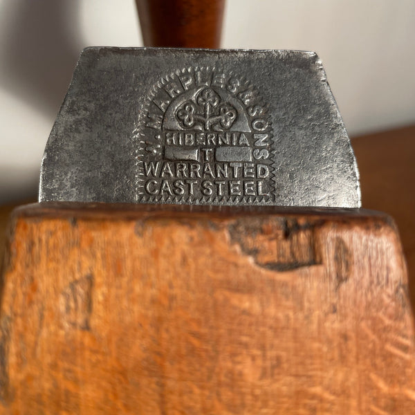 Vintage carpenters plane close up of original branding on metal cutting blade, crafted by shades at grays.