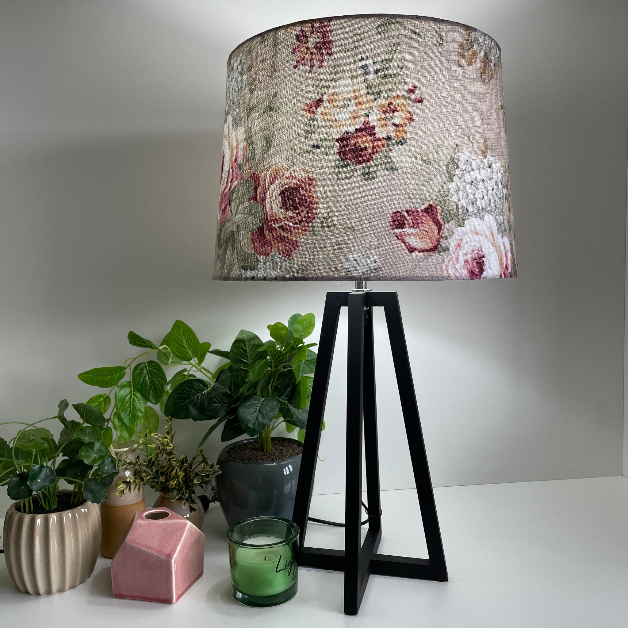 Large tapered lampshade with vintage style floral pattern, on medium height lampbase, lit, by shades at grays.