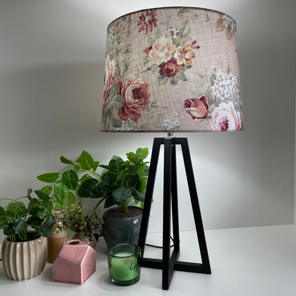 Large tapered lampshade with vintage style floral pattern, on medium height lampbase, lit, by shades at grays.