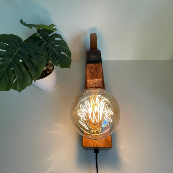 Vintage table lamp, old wood plane with edison bulb, crafted by shades at grays, nz. Close up of lit bulb.