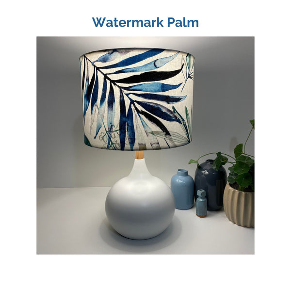 Watermark palm fabric on white touch lamp, lit, crafted by shades at grays.