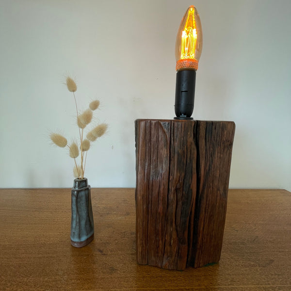 Wharf timber table lamp with candle bulb and deep brown grain, upcycled by shades at grays, front view.