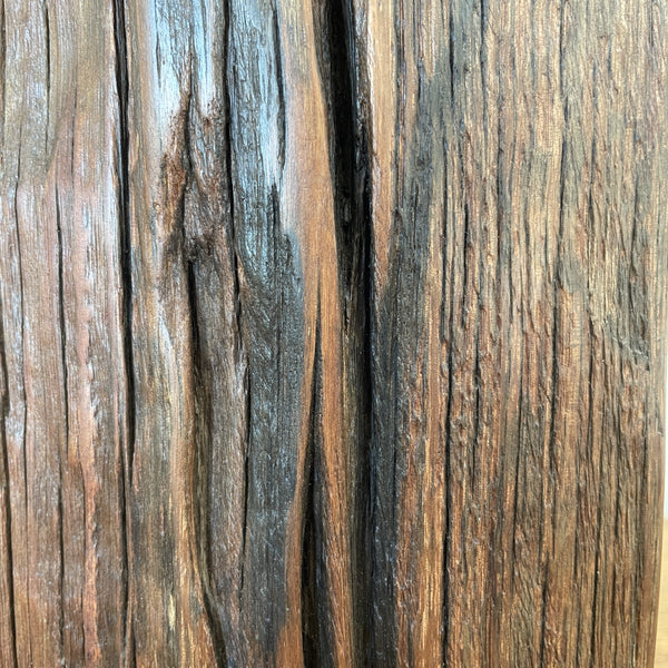 Wharf timber table lamp with candle bulb and deep brown grain, close up.