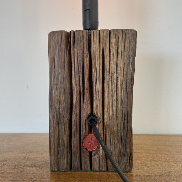 Wharf timber table lamp with candle bulb and deep brown grain, upcycled by shades at grays, back view.