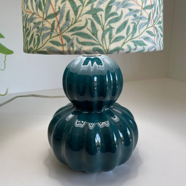 Willow boughs table lamp, by shades at grays, lit, close up of teal ceramic base.