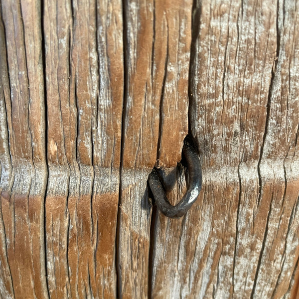 Close-up of a wire staple embedded in a wooden surface
