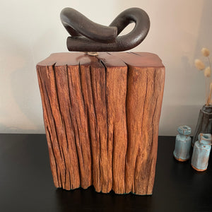 Wood door stop crafted from wharf timber with authentic railway pandrol clip, front view.