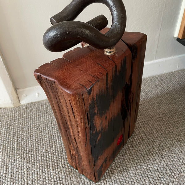 Wood door stop with authentic tar marks and erosion grooves, and polished railway pandrol clip, crafted by shades at grays, back and right side.