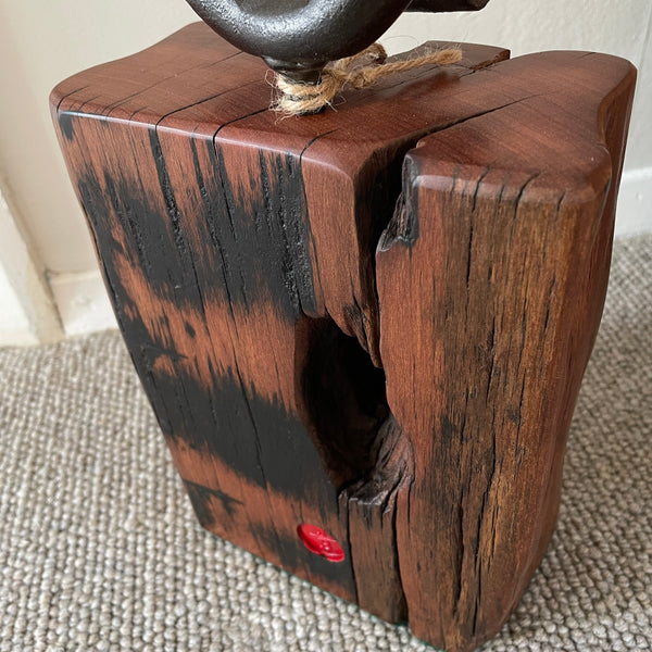 Wood door stop with authentic tar marks and erosion grooves, and polished railway pandrol clip, crafted by shades at grays, back and top view.