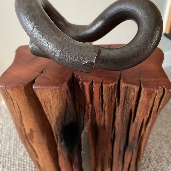 Wood door stop with authentic tar marks and erosion grooves, and polished railway pandrol clip, crafted by shades at grays, close up of front and top view.