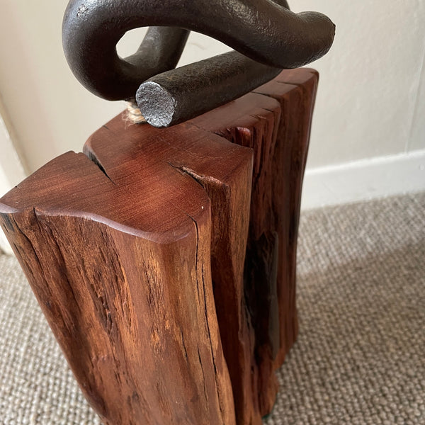 Wood door stop with authentic tar marks and erosion grooves, and polished railway pandrol clip, crafted by shades at grays, close up of side and top view.