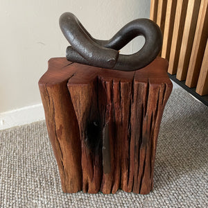 Wood door stop with authentic tar marks and erosion grooves, and polished railway pandrol clip, crafted by shades at grays, front view.