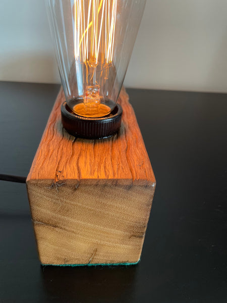 Wooden table lamp upcycled from old telegraph pole with edison bulb, close up of smooth left side.