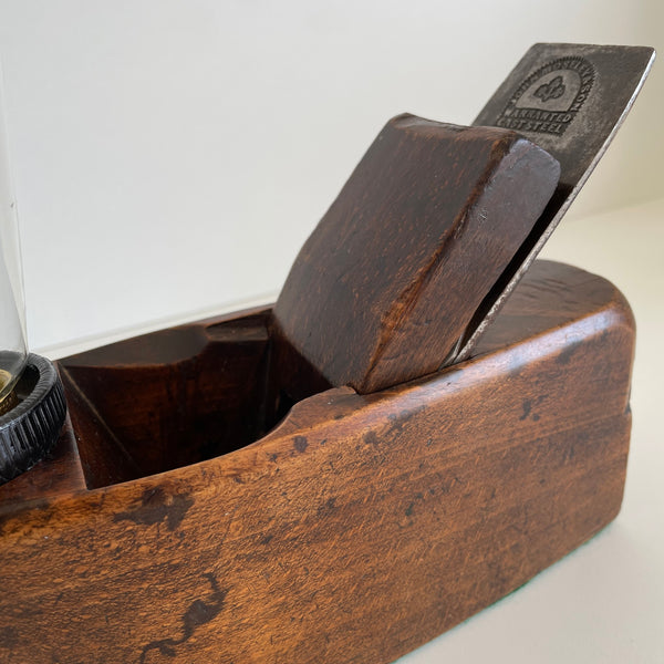 Wooden table lamp, handcrafted from vintage carpenter's plane, dark honey wood and edison bulb, close up and cutting blade.