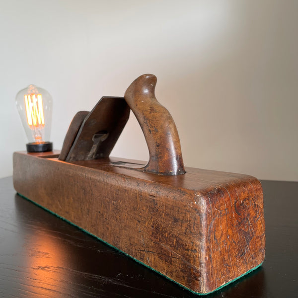 Wooden table lamp crafted from vintage carpenter's plane, cleaned and polished with natural beeswax, close up of side and end.