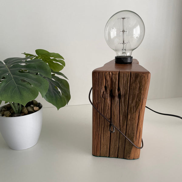 Wooden table lamp handcrafted from rustic totara fence post, by shades at grays, unlit.