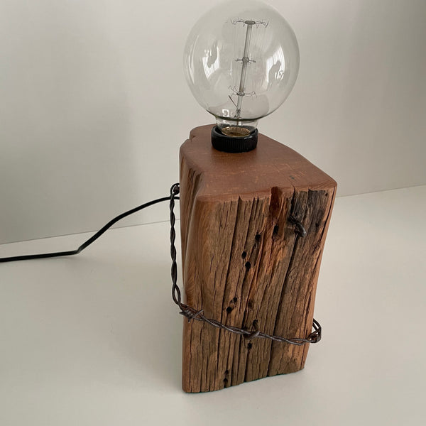 Wooden table lamp handcraafted from totara post with original fence wire, front view, unlit.