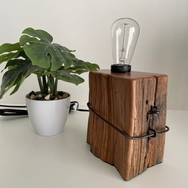 Wooden table lamp handcrafted from vintage totara post with original wire and replica edison bulb, unlit.