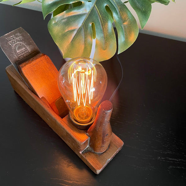 Wooden table lamp upcycled from vintage carpenter's plane by shades at grays, nz, top view with lit edison bulb.