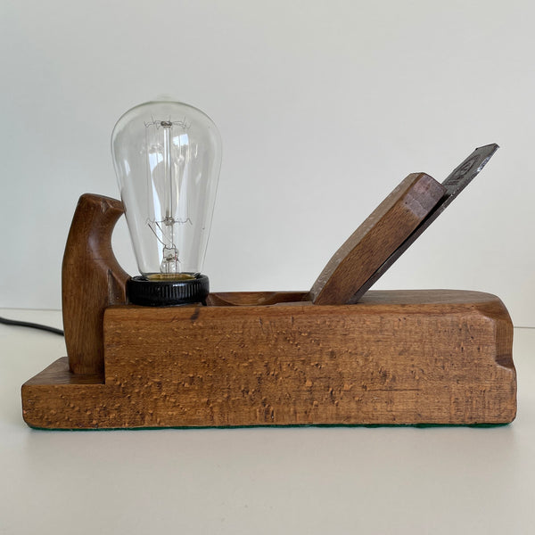 Wooden table lamp crafted from old carpenter's wood block plane, with edison bulb, unlit.