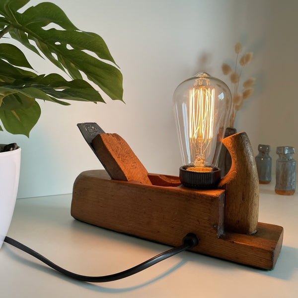 Wooden table lamp upcycled from vintage carpenters plane with edison bulb, back view with black lead.