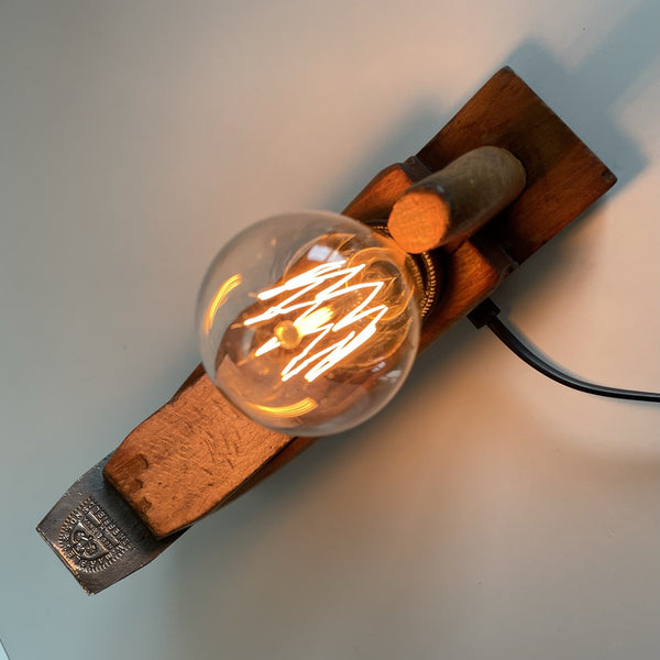 Wooden table lamp upcycled from vintage carpenters plane with edison bulb, top view of bulb and authentic cutting blade.