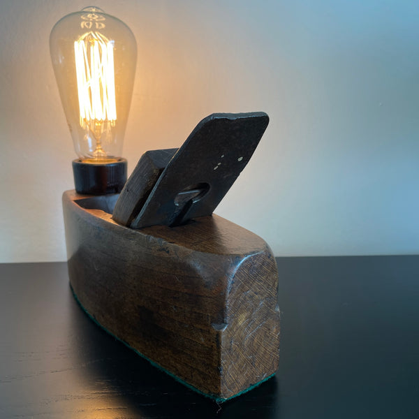 Wood lamp created by shades at grays from vintage wood plane, back and side view, lit.