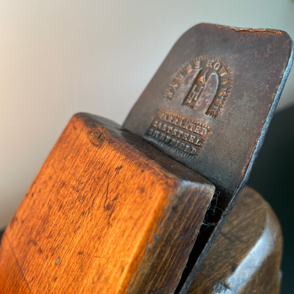 Wood lamp created by shades at grays from vintage wood plane, close up of branded cutting blade.