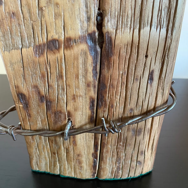 Wood table lamp crafted from reclaimed tōtara post with authentic barbed wire and the adition of an edision bulb, close up authentic barbed wire by shades at grays.