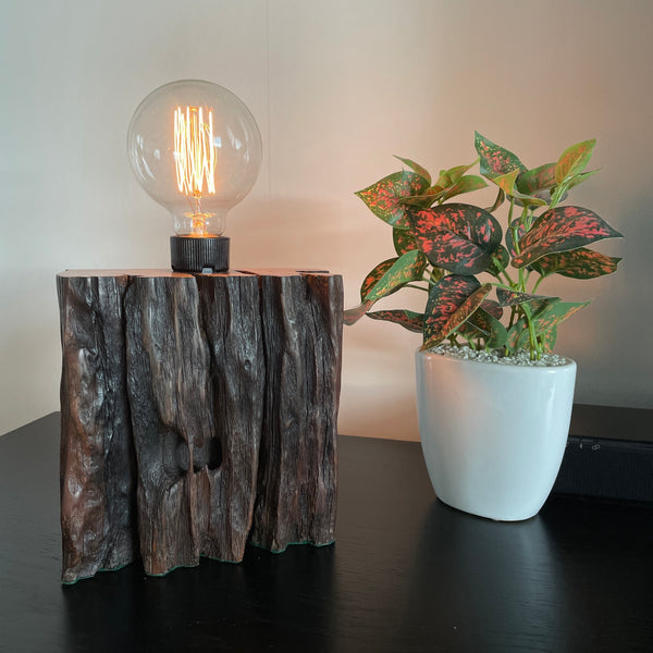 Wood table lamp from reclaimed railway sleeper, with natural erosion and replica edison lamp crafted by shades at grays, with replica edison bulb, lit.