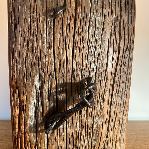Wood table lamp handcrafted by Shades at Grays from authentic tōtara post, edison bulb, lit, close up of wire, staples and wood grain.