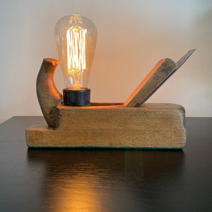 Wood table lamp made from vintage wood block with replica edison bulb, by shades at grays, front view, lit