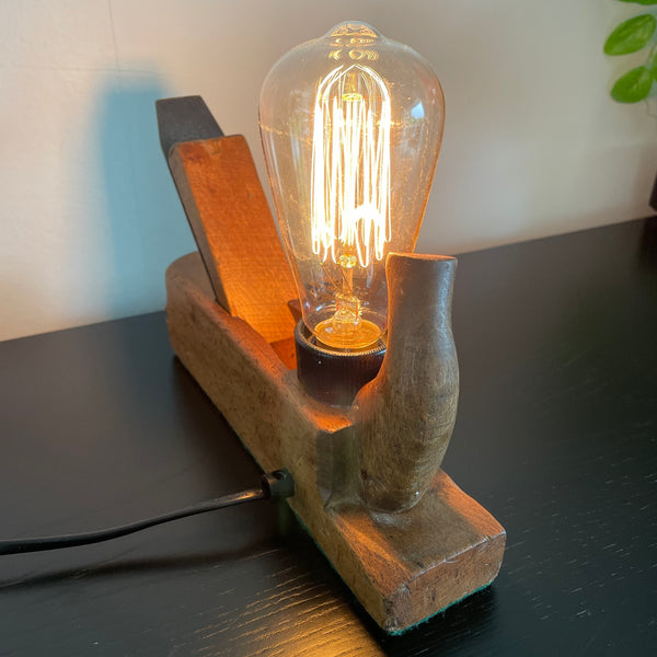 Wood table lamp made from vintage wood block with replica edison bulb, by shades at grays, side and back  view, lit