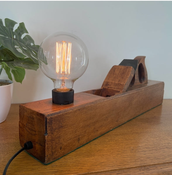 Wood table lamp upcycled from vintage carpenters plane, long view of front and back, with edison bulb, lit by shades at grays