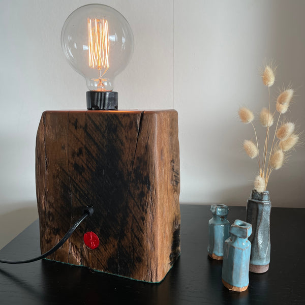 Wood table lamp upcycled from wharf timber, with edison lightbulb, lit, back view, crafted by shades at grays.