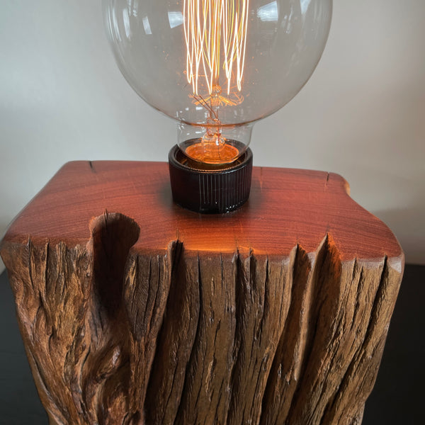 Wood table lamp upcycled from wharf timber, with edison lightbulb, lit, front and smooth top view, crafted by shades at grays.