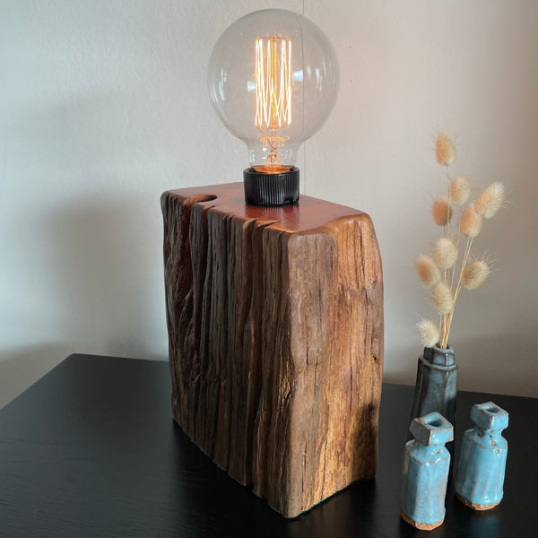 Wood table lamp upcycled from wharf timber, with edison lightbulb, lit, front and side view, crafted by shades at grays.