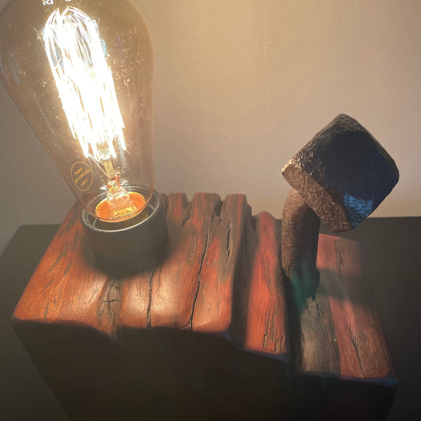 Wood table lamp upcycled from wharf timber with large vintage bolt and replica edison bulb, lit, close up of erosion grooves and bolt, handcrafted by shades at grays.