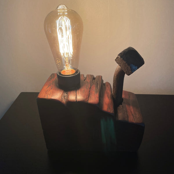Wood table lamp upcycled from wharf timber with large vintage bolt and replica edison bulb, lit, front view, handcrafted by shades at grays.