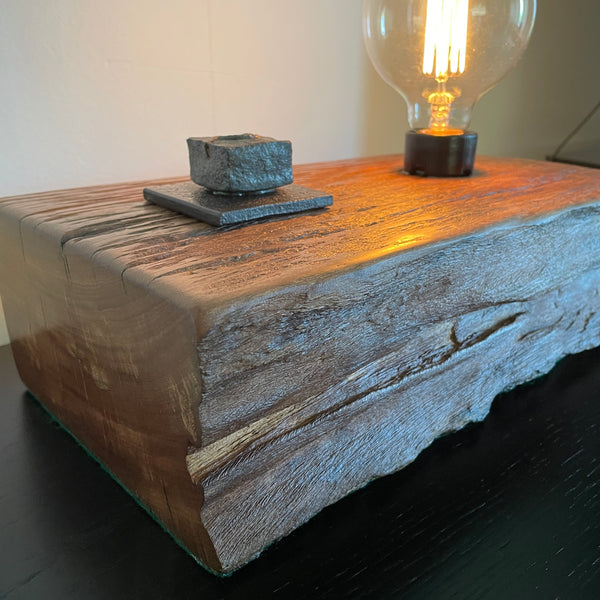 Wood table lamp upcycled from wharf timber with original bolt and edison bulb, close up of front and side by shades at grays.